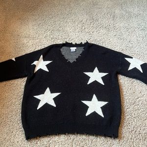 Black sweater with large white stars and frayed edges